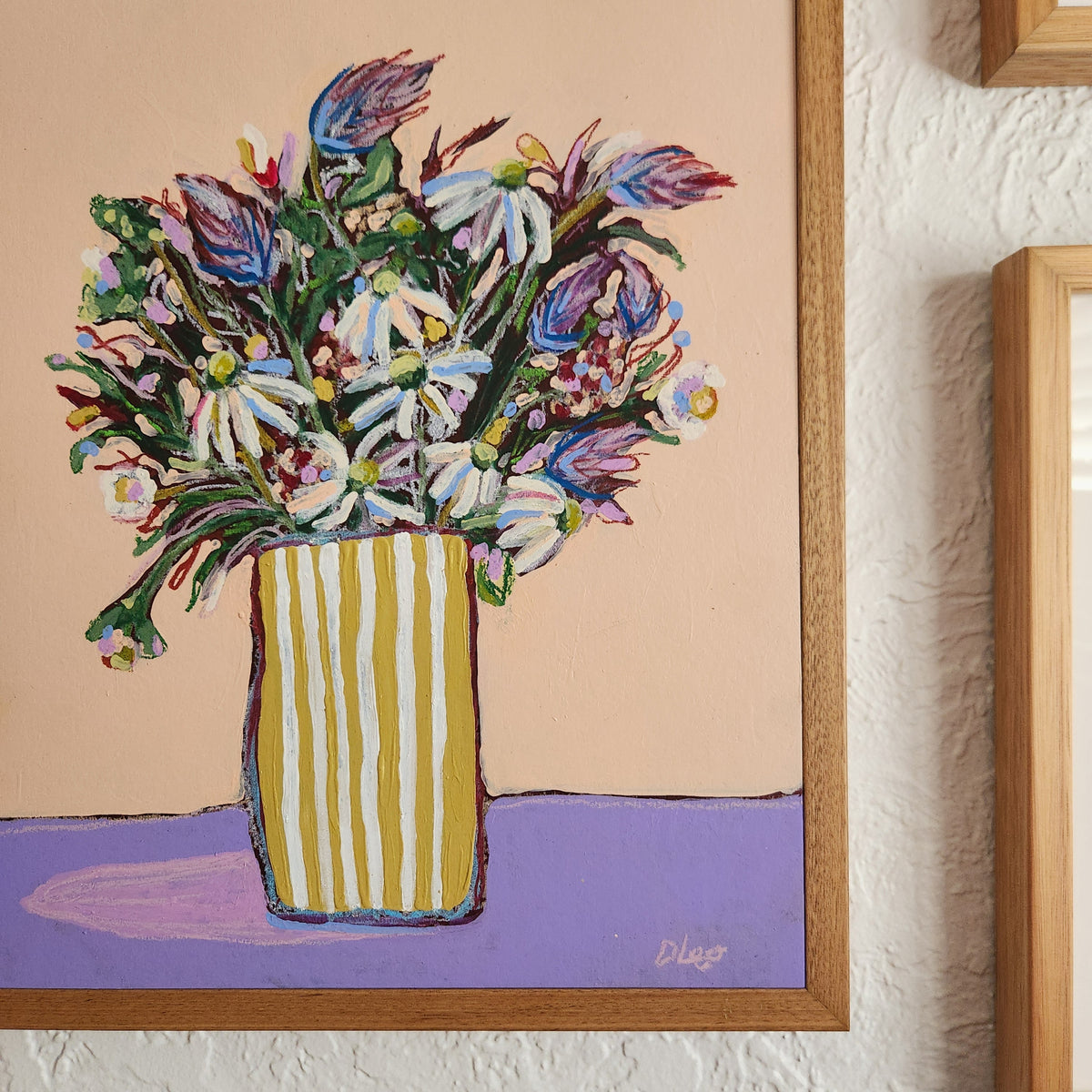 Colorful floral arrangement in a striped vase against a beige background
