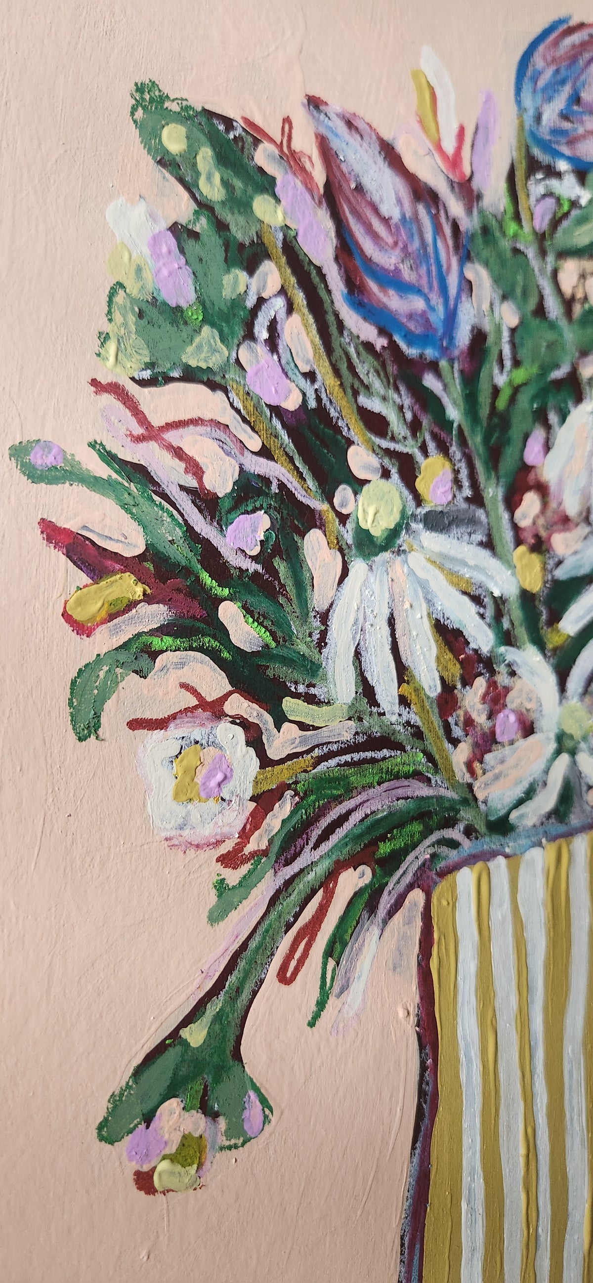 Colorful floral arrangement in a striped vase against a beige background